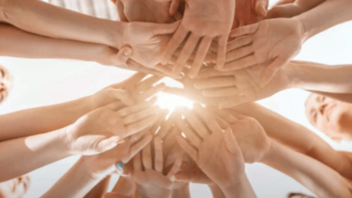 Photographie de femmes tendant et joignant leurs mains ensemble.