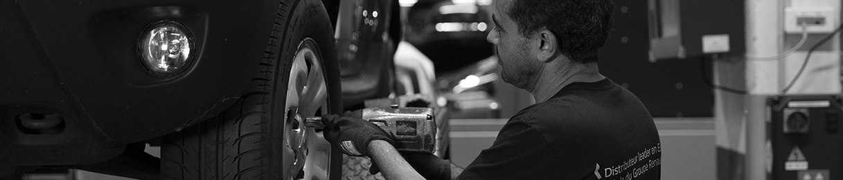 Photographie d'un collaborateur travaillant sur un véhicule en portant une attention soignée aux détails.